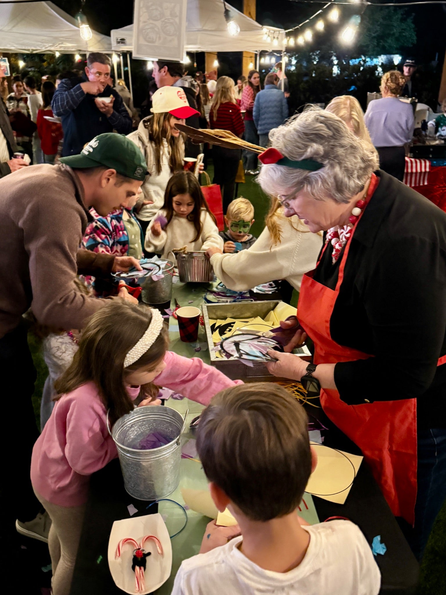 Children and adults making crafts together around a table at a past family Christmas celebration